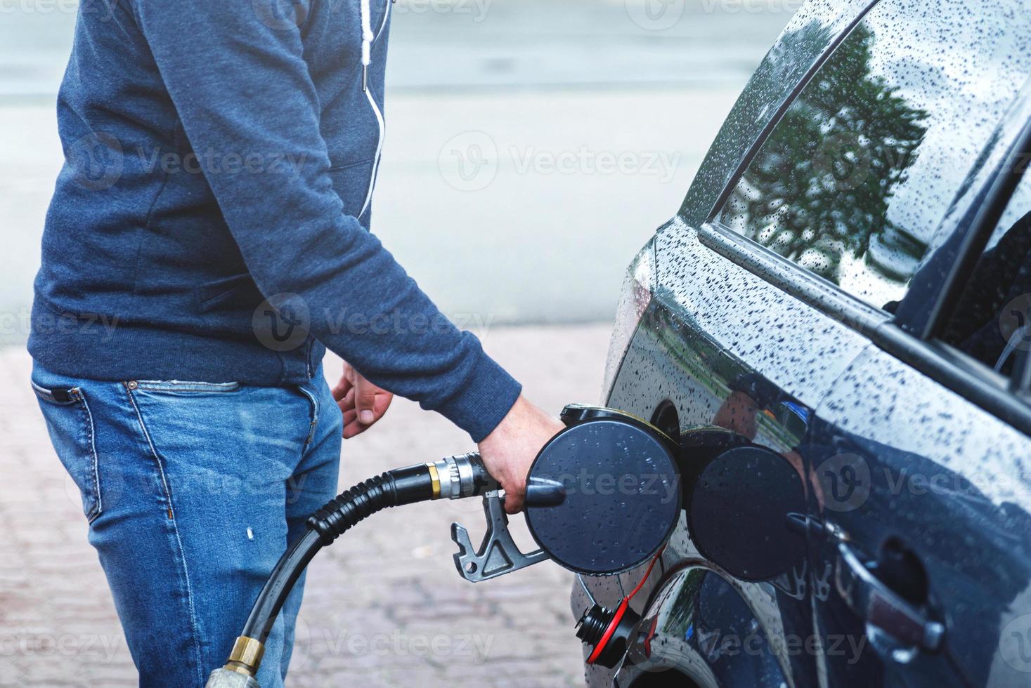 Man is filling tank of his car on the gas station photo