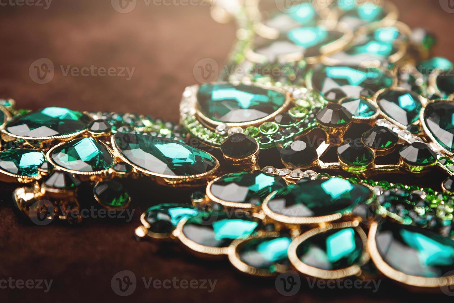 Luxury necklace with green gemstones on the brown velvet photo