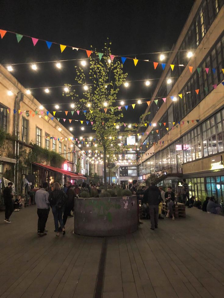 People walk along the modern pedestrian night street with flags and bulbs, boutiques with cafes, bars and restaurants in the city center. Georgia, Batumi, April 17, 2019 photo