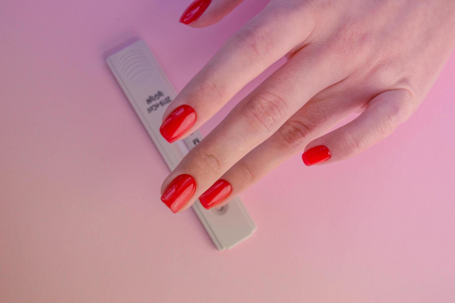 coronavirus test on a pink matte background. medical procedure. medical analysis. bright red manicure next to the covid test photo