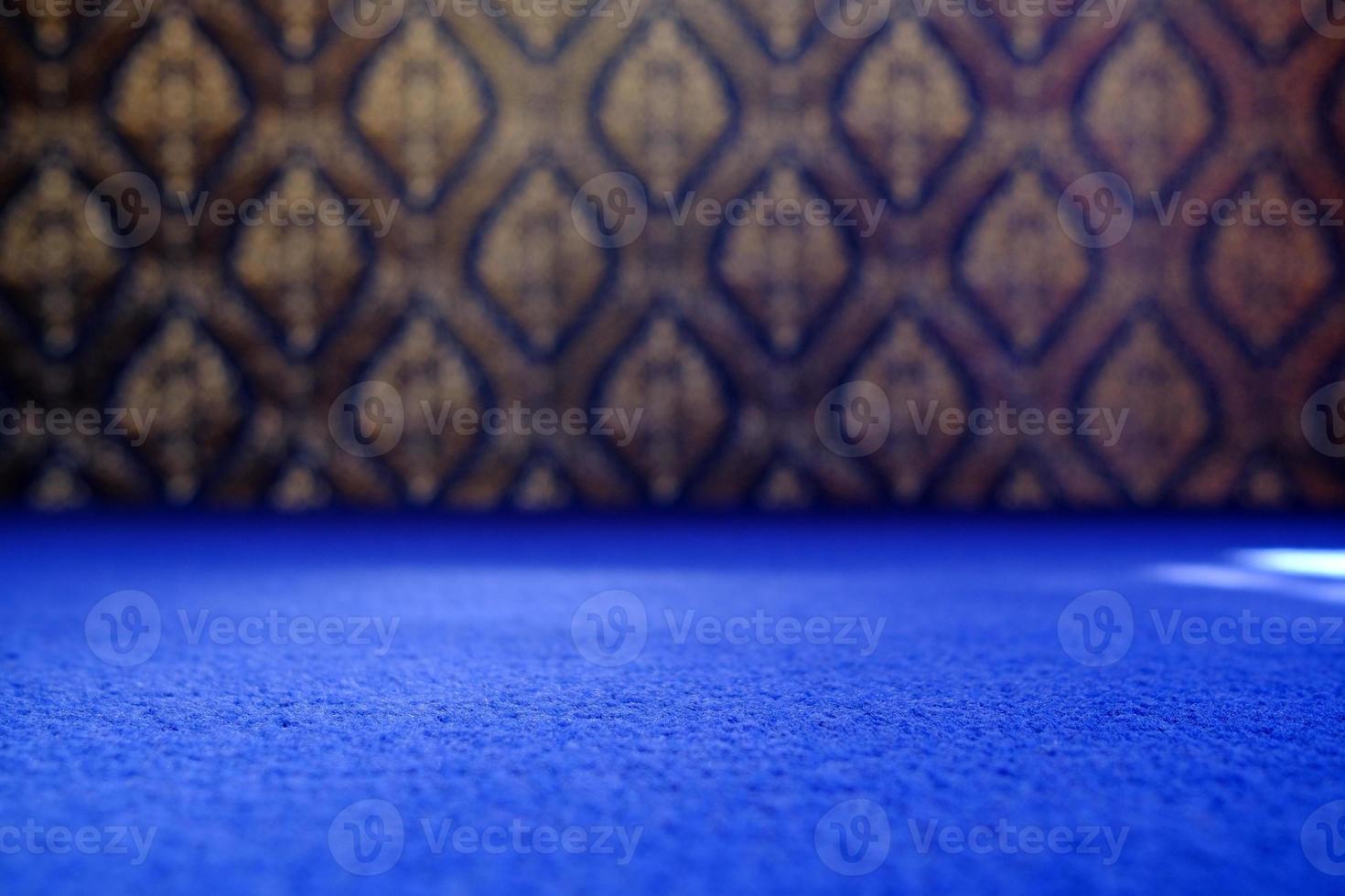 Blue Carpet Floor in Selective Focus with Blurred Vintage Traditional Thai Mural Art Background, Suitable for Product Presentation Backdrop, Display, and Mock up. photo