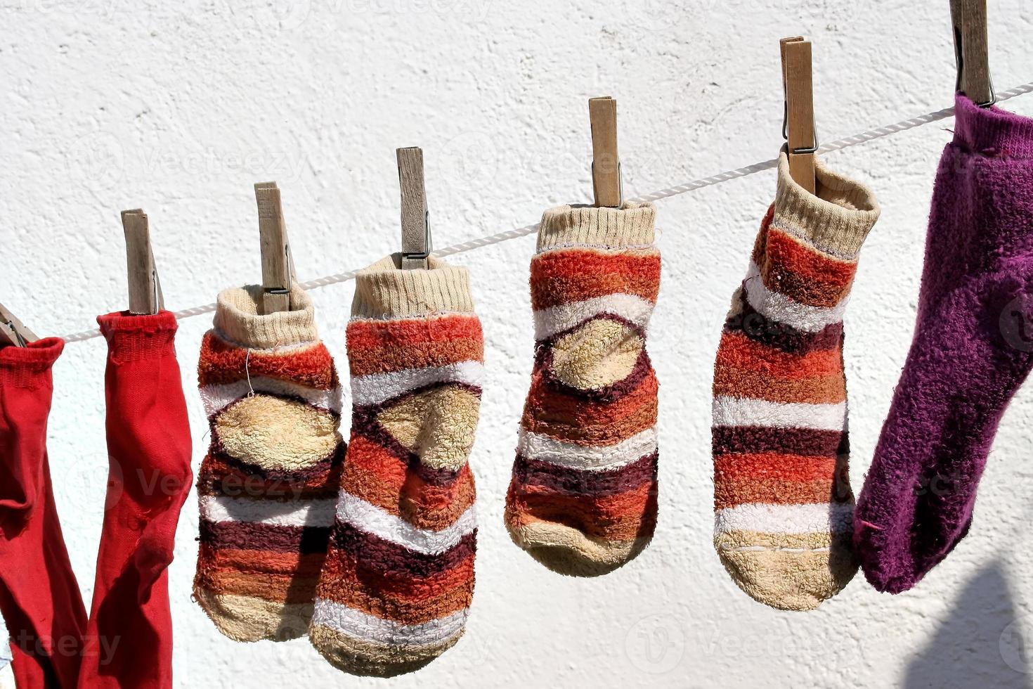 Socks hanging from a rope with white wall. Horizontal image. photo