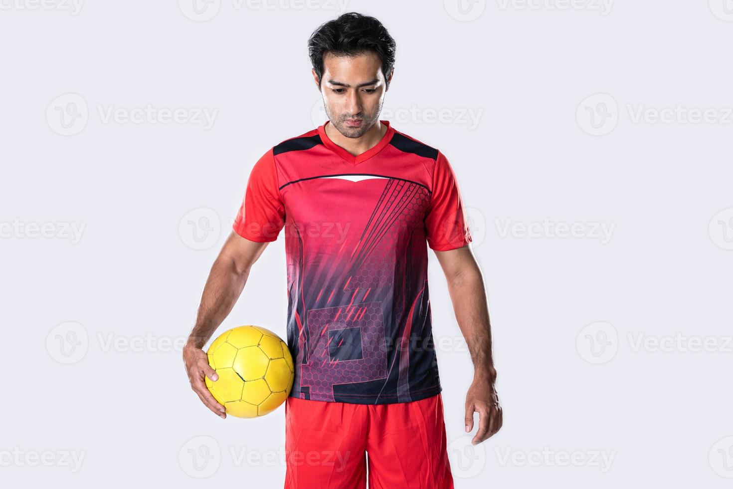 jugador de fútbol profesional en pose de uniforme de entrenamiento rojo sobre un fondo blanco concepto de fútbol activo. foto