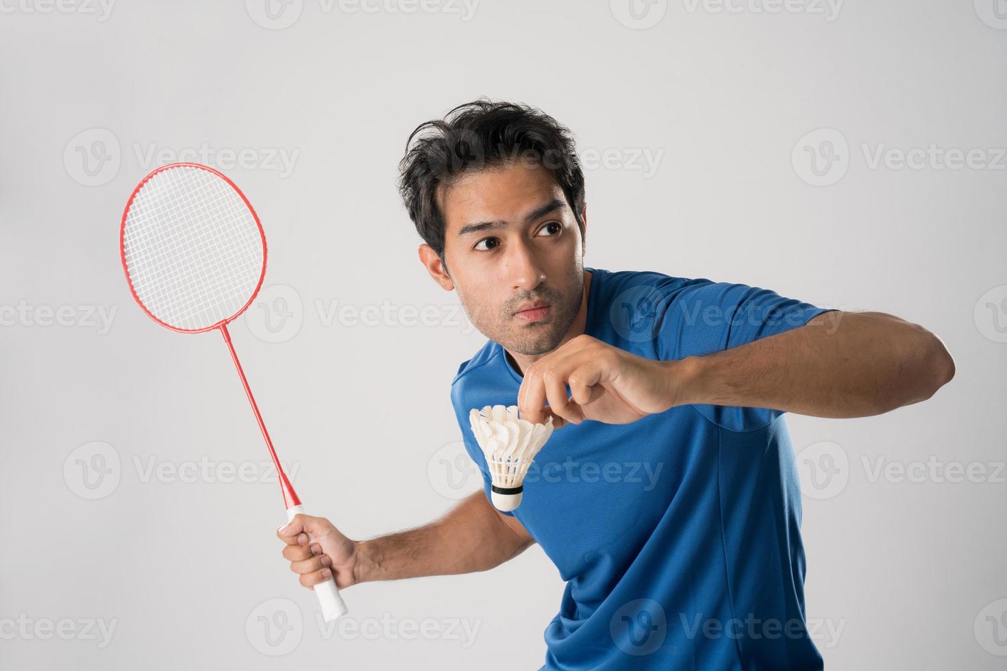 un jugador de bádminton con ropa deportiva sostiene una raqueta y un volante. foto