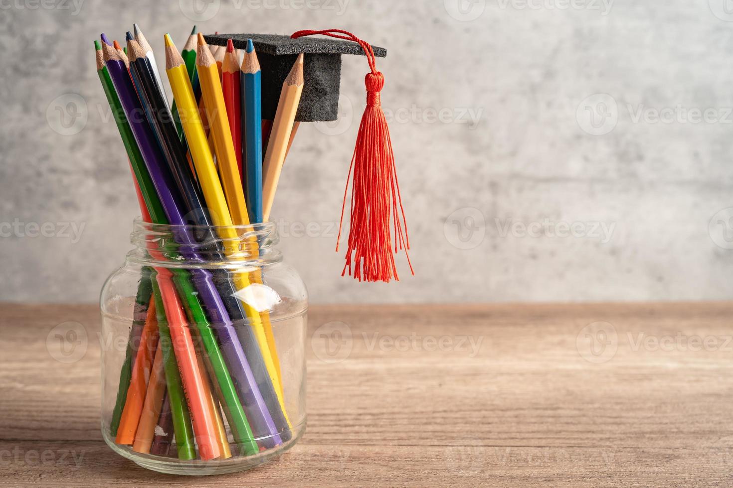 Graduation hat with colorful pencils on book with copy space, learning university education concept. photo