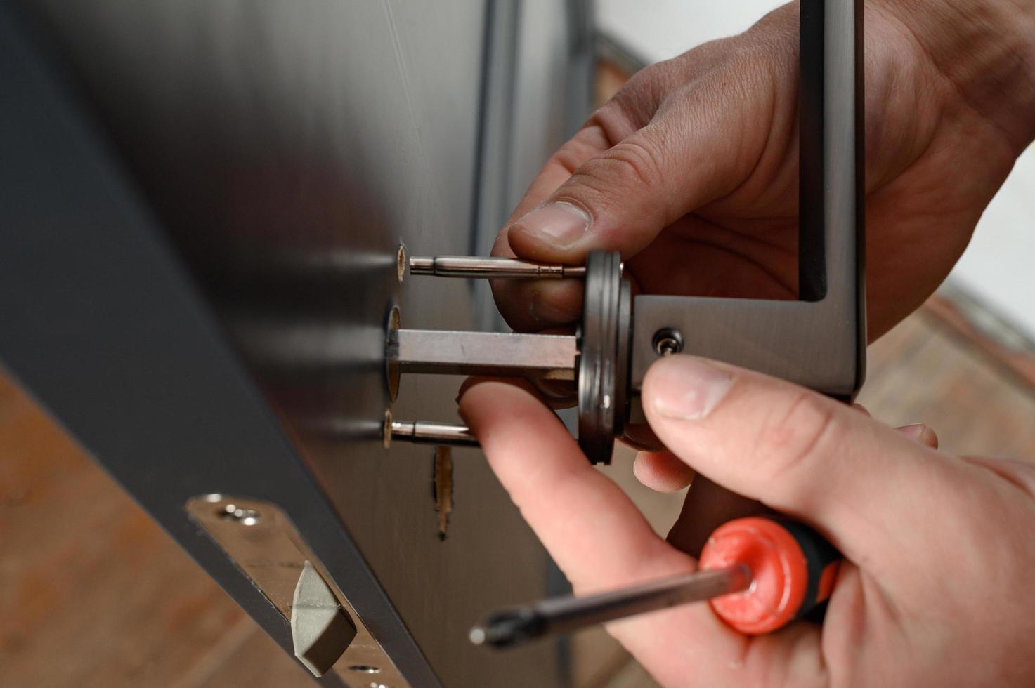 A man installs a doorknob in a door, carpentry at home. photo