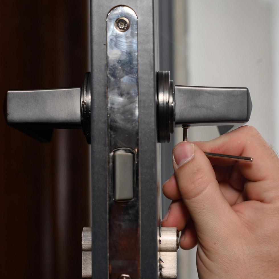 Hex key and installation of door lock and handle, close-up of installation work. photo