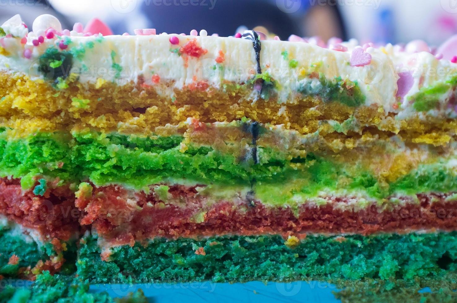 Tasty, appetizing piece of cake with multi-colored bright layered. Festive sweet dessert. Close-up. photo