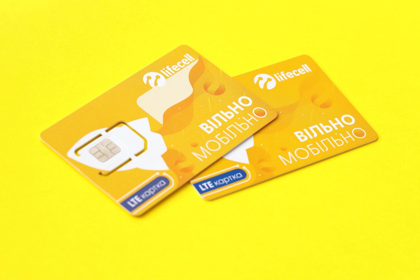 TERNOPIL, UKRAINE - JULY 5, 2022 Lifecell new sim card with free contract on yellow background. Lifecell is ukrainian mobile telephone network operator and provider of wireless connection photo