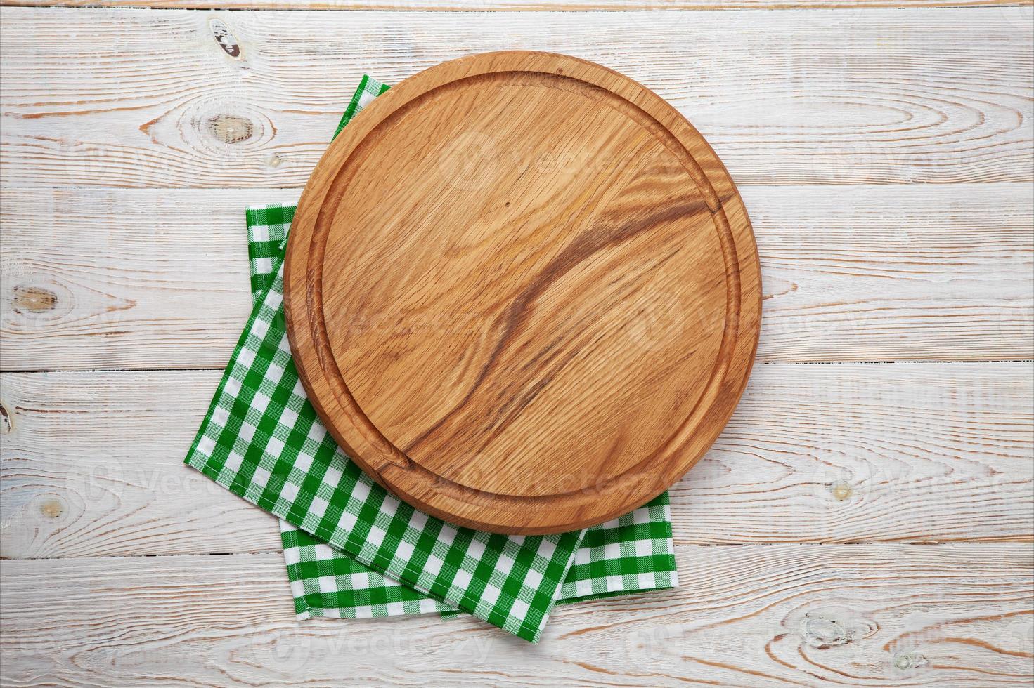 Empty pizza board and napkin on white wooden top view. photo