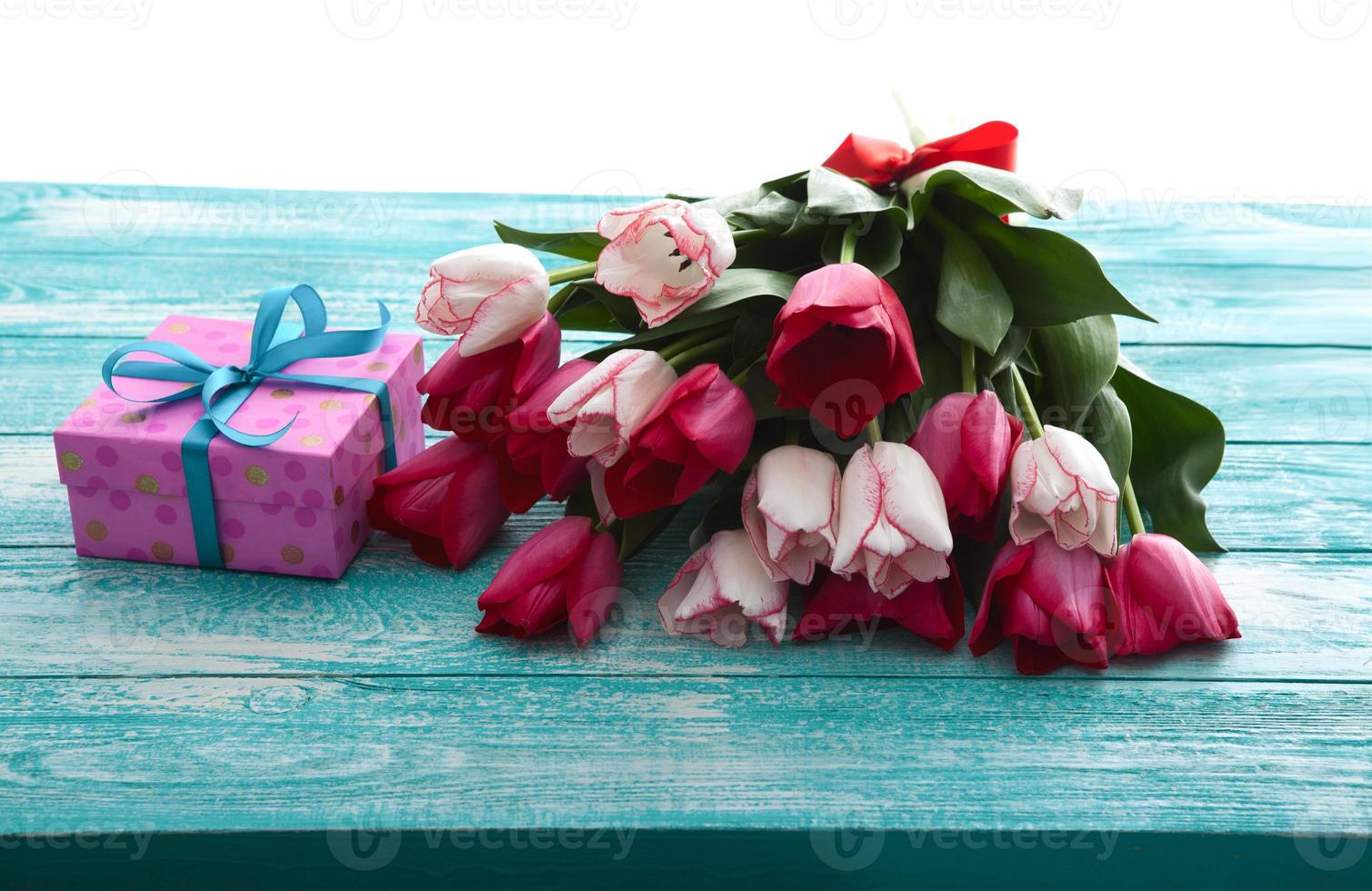 día de la madre, día de la mujer. tulipanes, regalos sobre fondo de madera foto