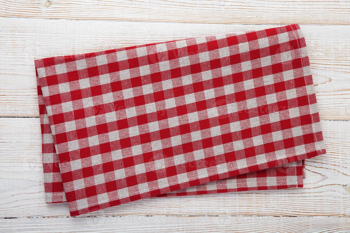 Blank red checkered napkin on a wooden table top view. photo