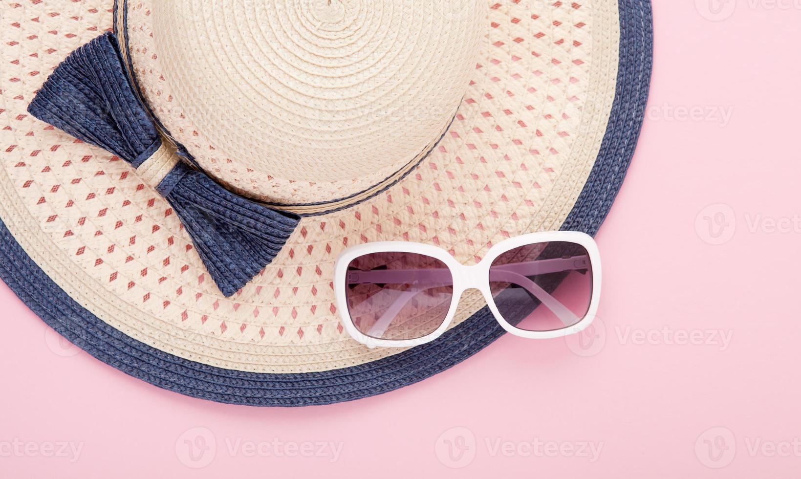 Summer hat with ribbon and sunglasses isolated on colorful background. Top view and copy space. photo