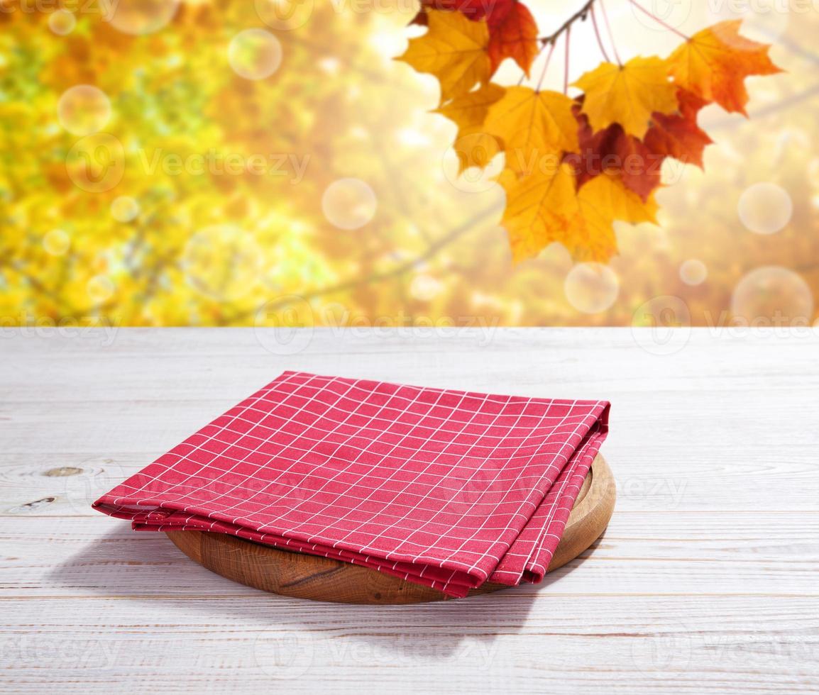 Empty pizza board and red napkin on white wooden photo