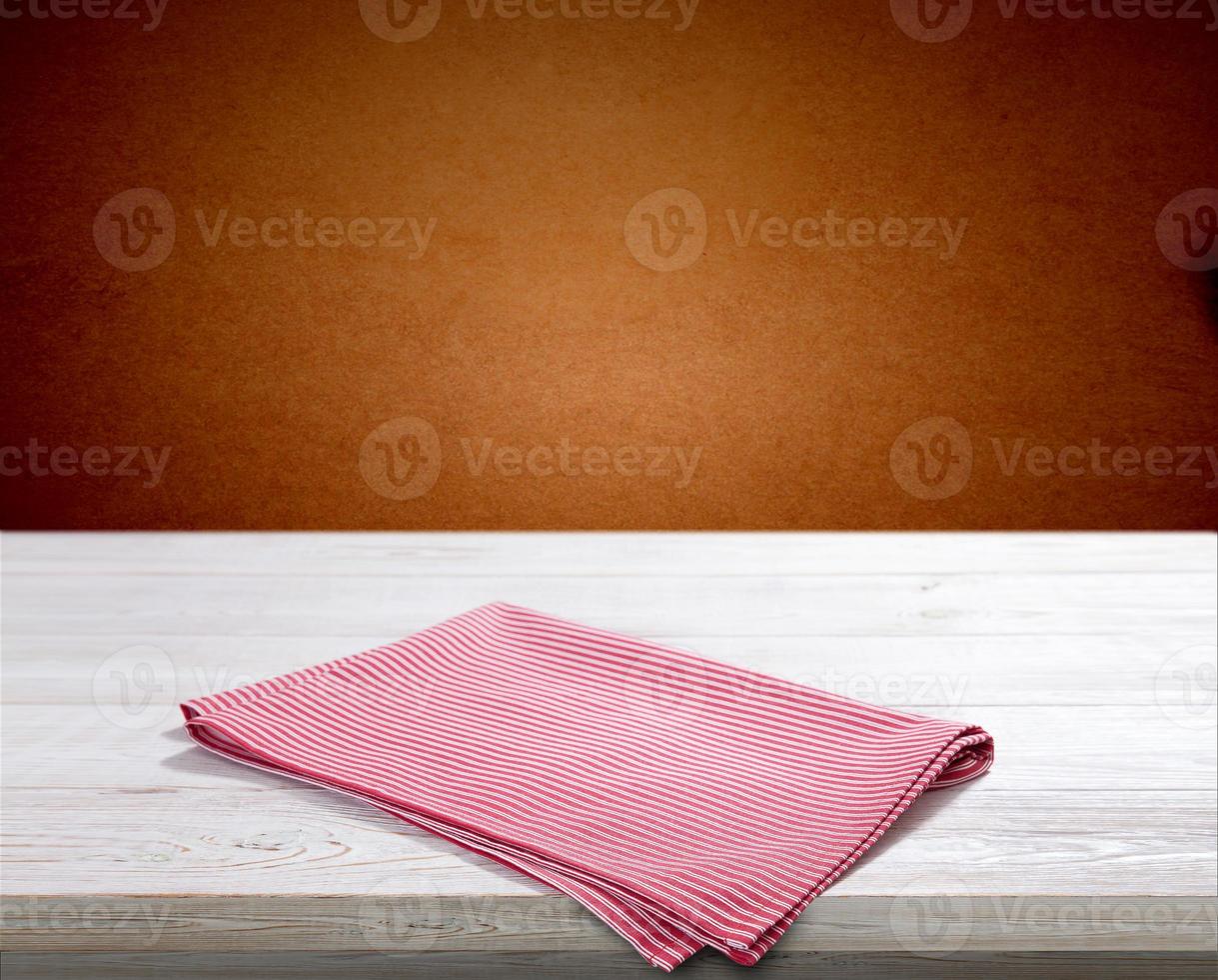 Red napkin on white wooden table top view photo