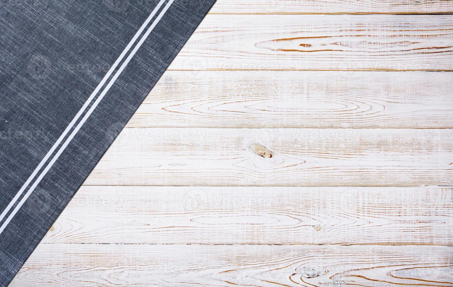 Smooth blue tablecloth, napkin, rough fabric texture on wooden desk top view. photo