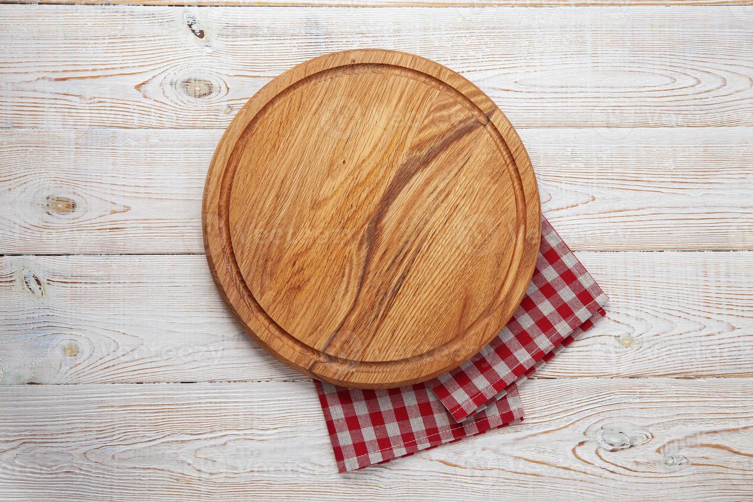 Empty pizza board and napkin on white wooden top view. photo