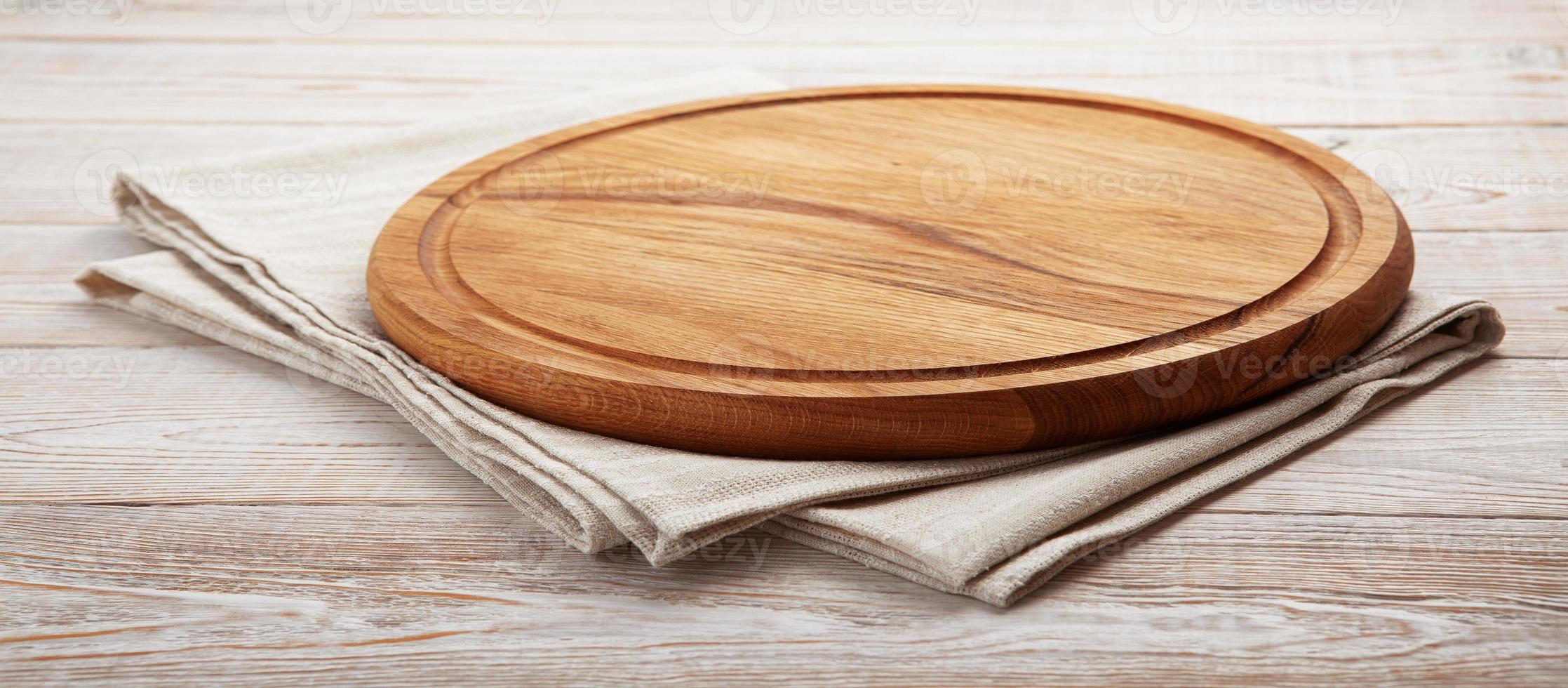 Empty pizza board and napkin on white wooden photo
