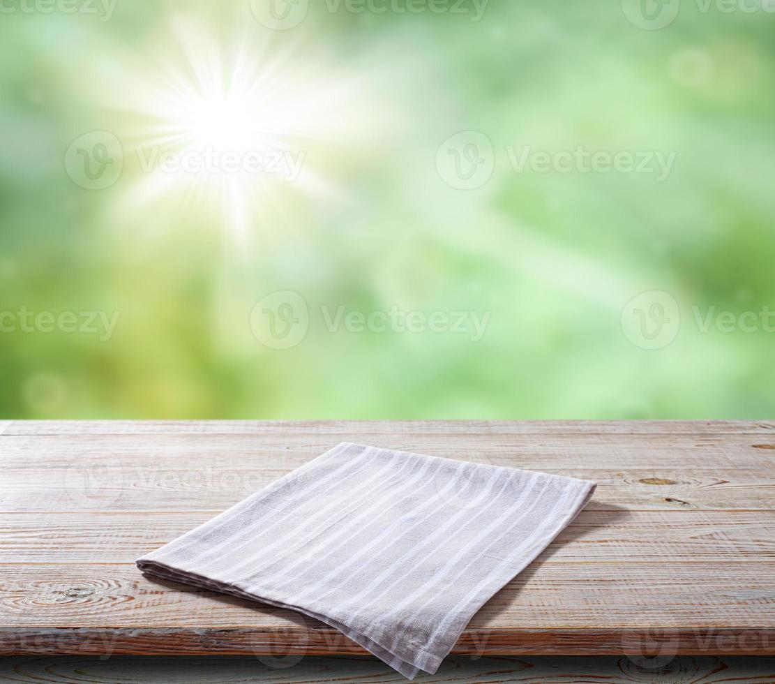 White napkin, table cloth on wooden deck mockup. Summer landscape background photo