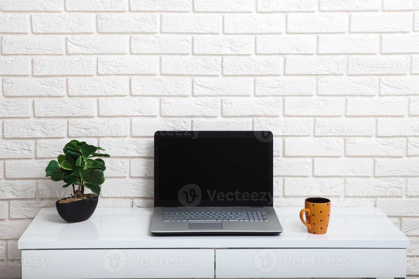 White table near the white wall. Empty workplace in the room. White background. photo