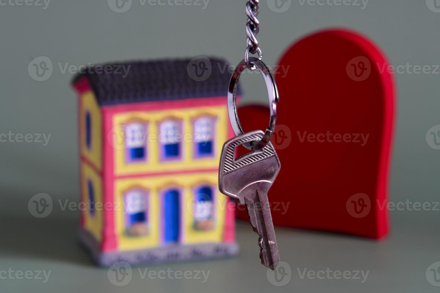 House symbol with metal key and property miniature, symbolizing home ownership photo