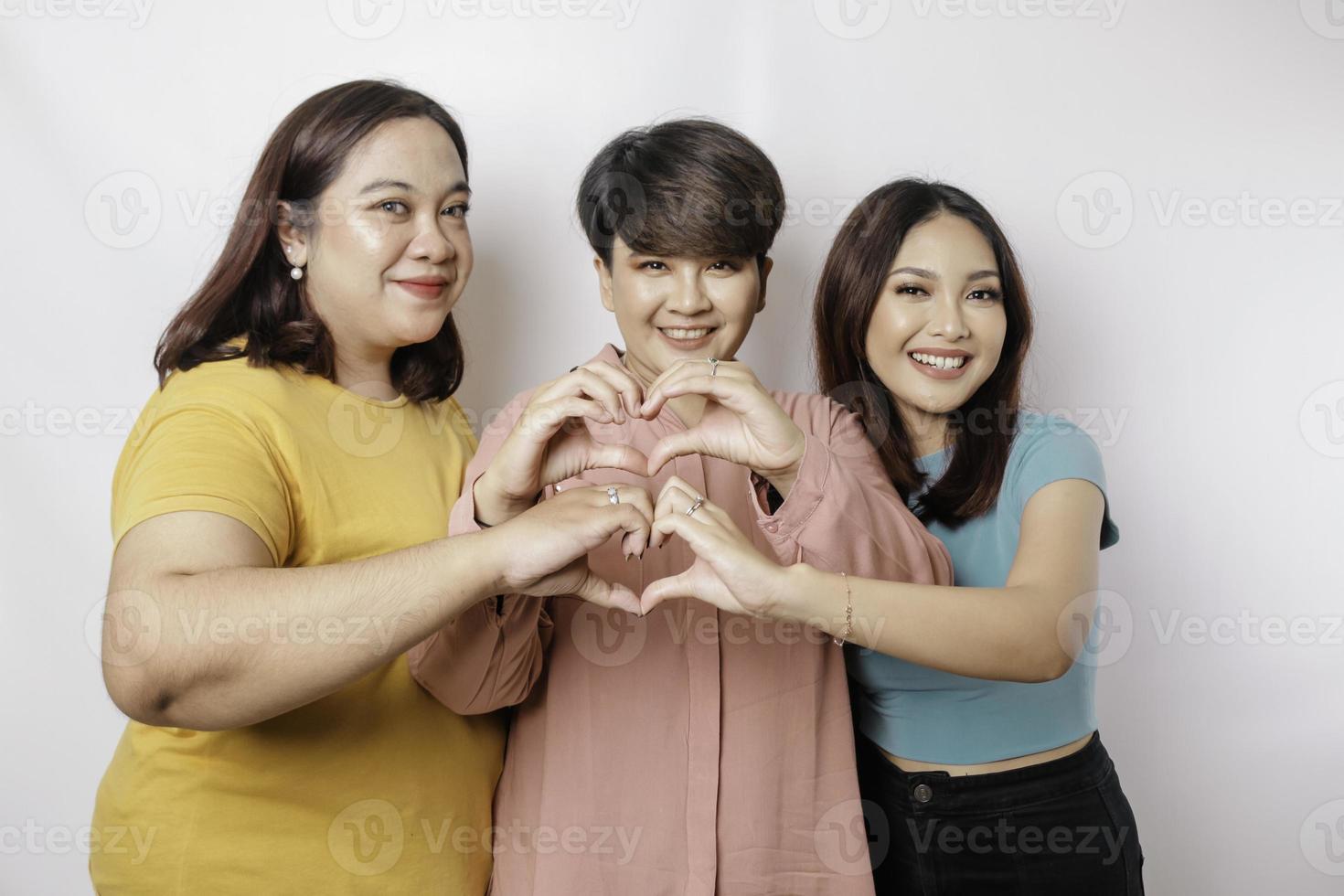 tres mujeres asiáticas se sienten felices y un gesto de corazón de formas románticas expresa sentimientos tiernos, concepto de amistad cercana. foto