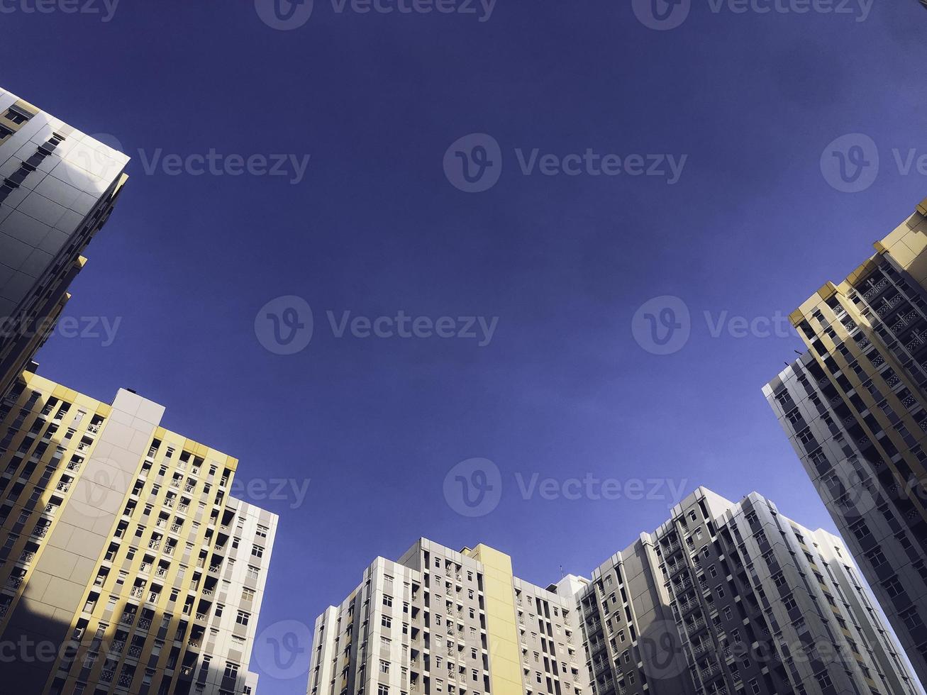 A portrait of skyscrapers or tower, high-rise buildings from below against the background of the blue sky photo