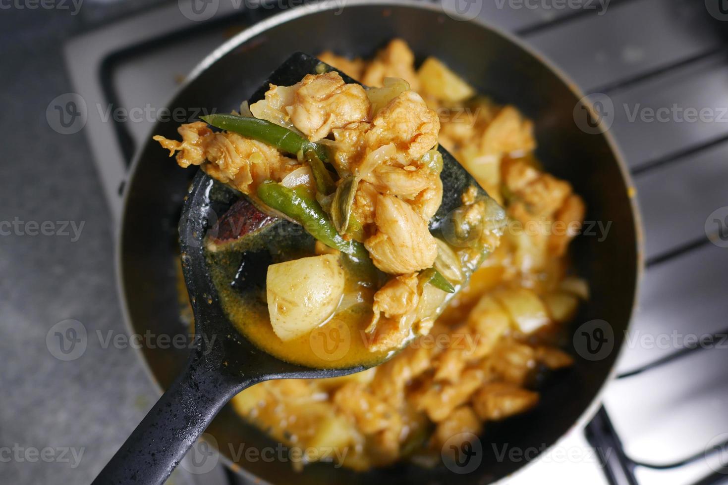 cooking chicken curry in a cooking pan photo