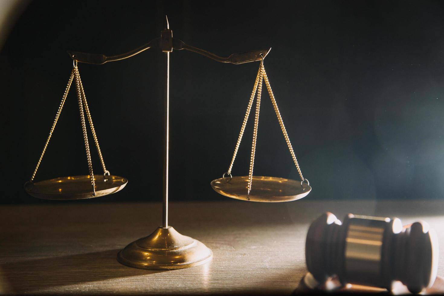 Business and lawyers discussing contract papers with brass scale on desk in office. Law, legal services, advice, justice and law concept photo