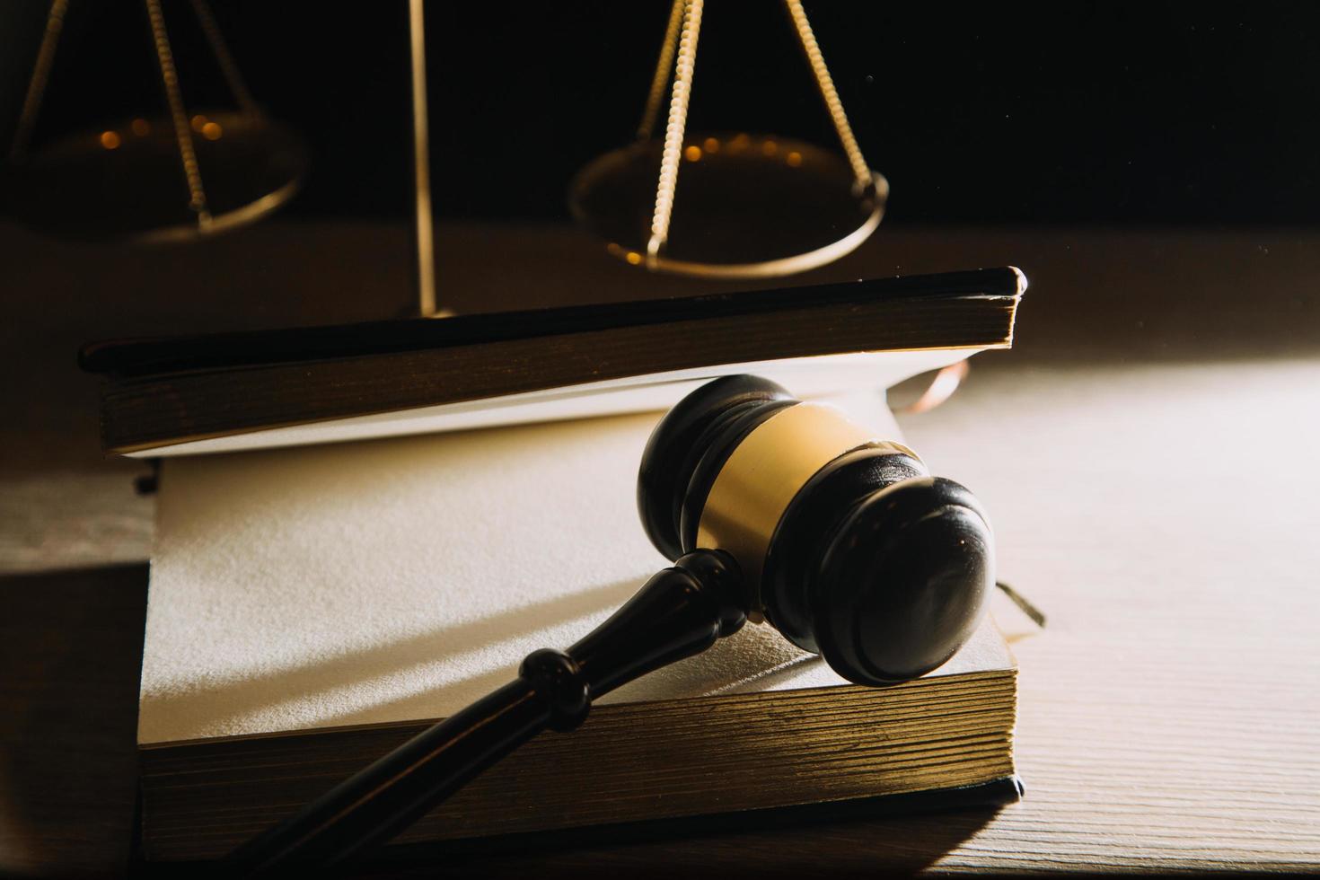 Business and lawyers discussing contract papers with brass scale on desk in office. Law, legal services, advice, justice and law concept photo