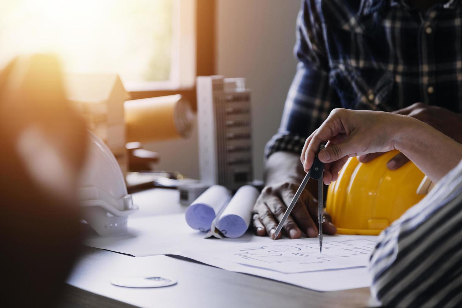 ingeniero de construcción que trabaja en planos para construir grandes edificios comerciales en la oficina. herramientas de ingeniería y concepto de construcción. foto