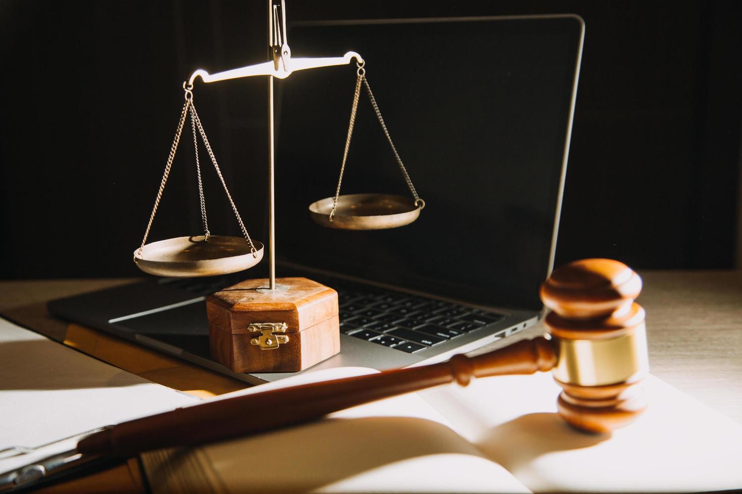 Business and lawyers discussing contract papers with brass scale on desk in office. Law, legal services, advice, justice and law concept photo