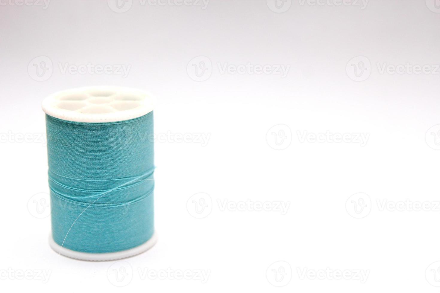 Green thread spools placed on a white background. photo