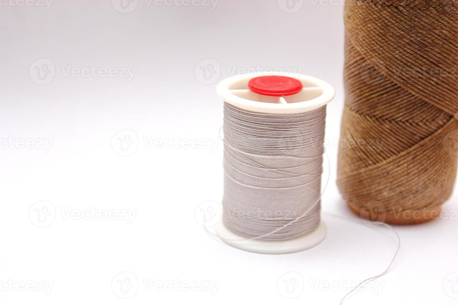 Gray and brown spools are placed on a white background. photo