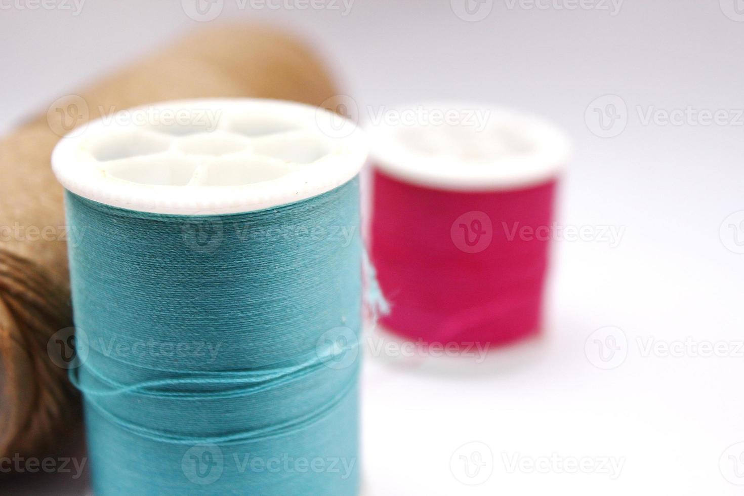 Green, red, brown spools placed on a white background. photo