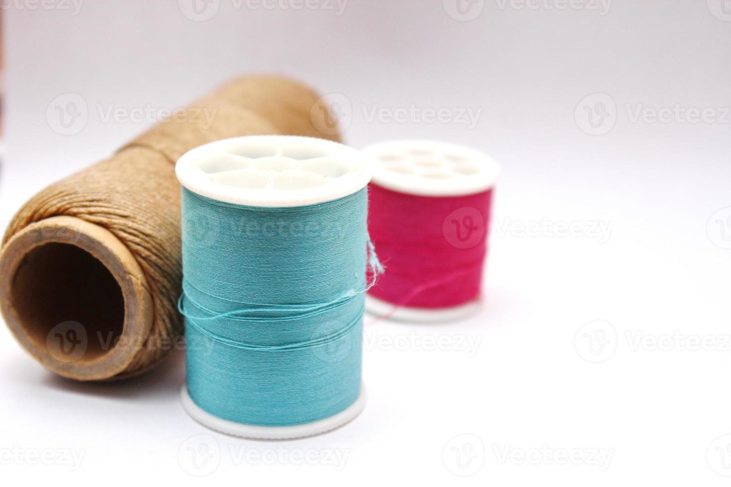 Green, red, brown spools placed on a white background. photo