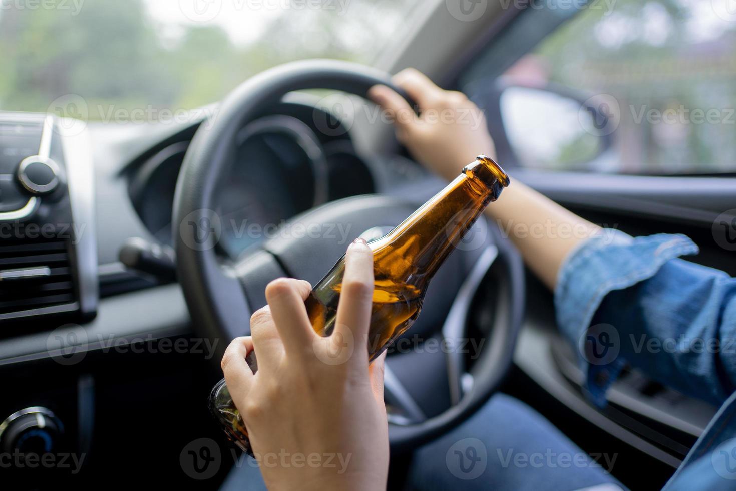 Young woman drinking beer while driving Risk of accidents due to drunk driving photo