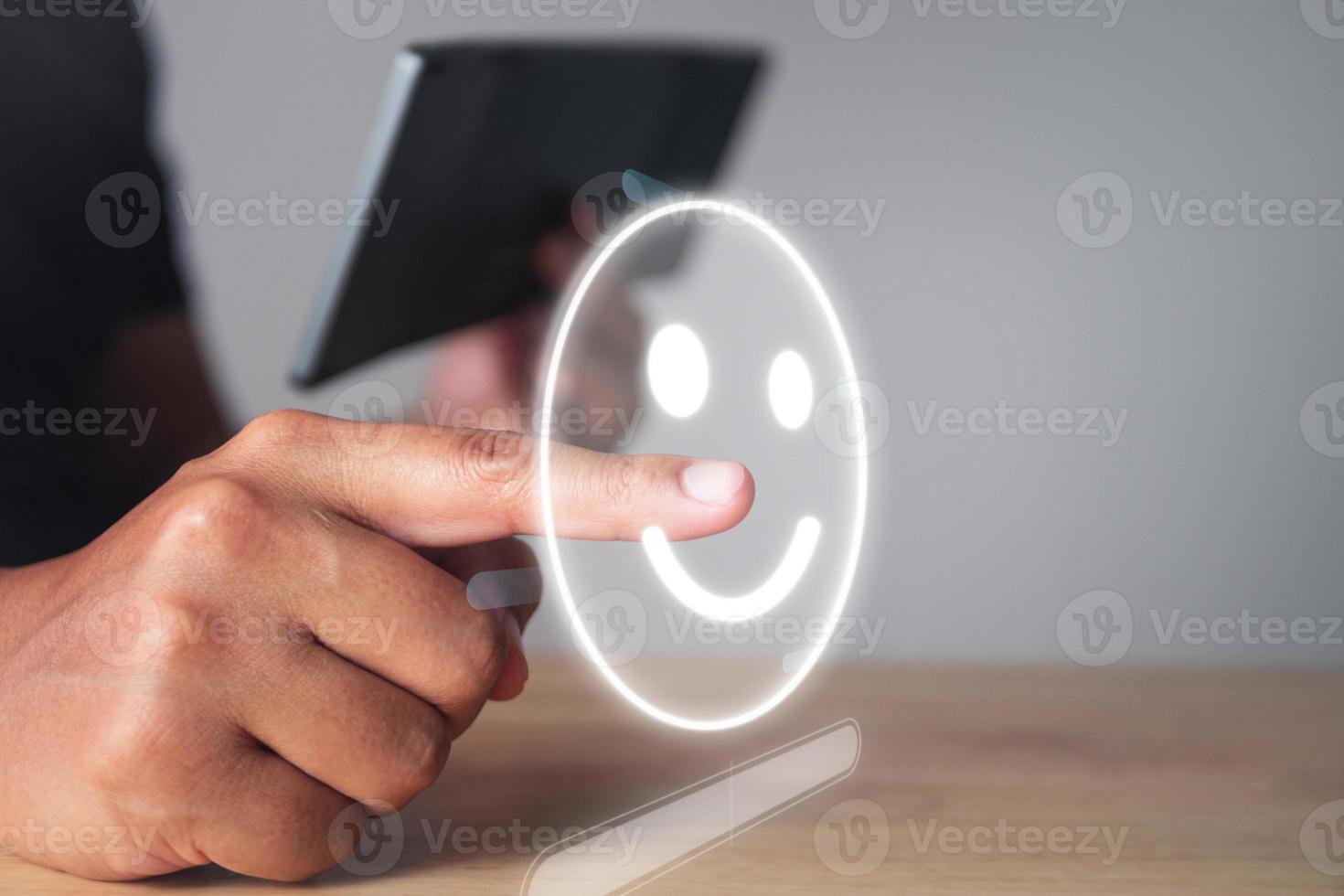 Evaluation and satisfaction concept. Someone chooses a smile emotion that is an excellent review with smart keyboard. Medium close up shot with virtual screen. photo