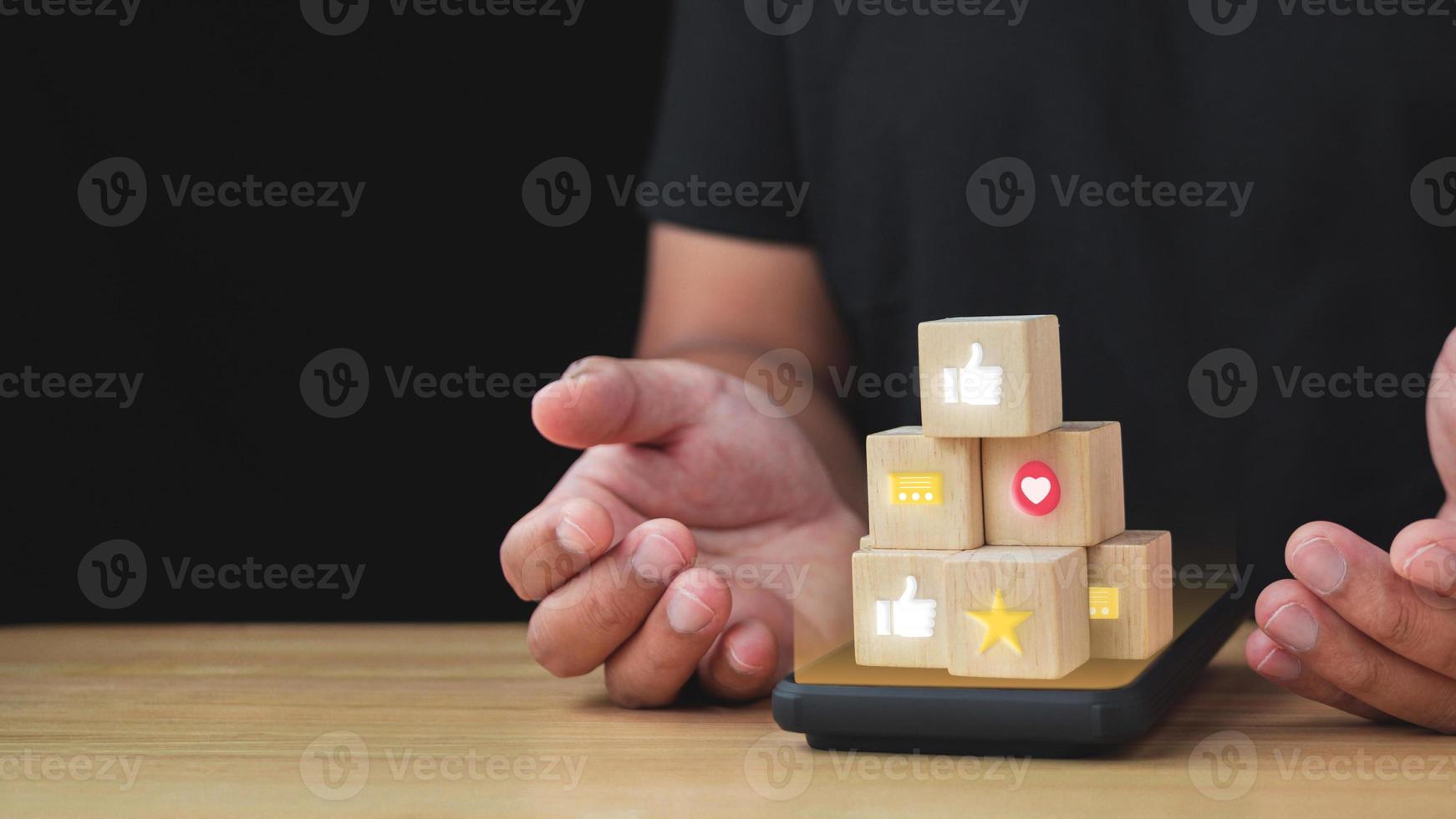 Creator feedback from subscriber. Wood blocks is on the smartphone that show an emotion and feeling. Such as Like, Star, Love. Evaluation and satisfaction concept. Copy space for text. photo