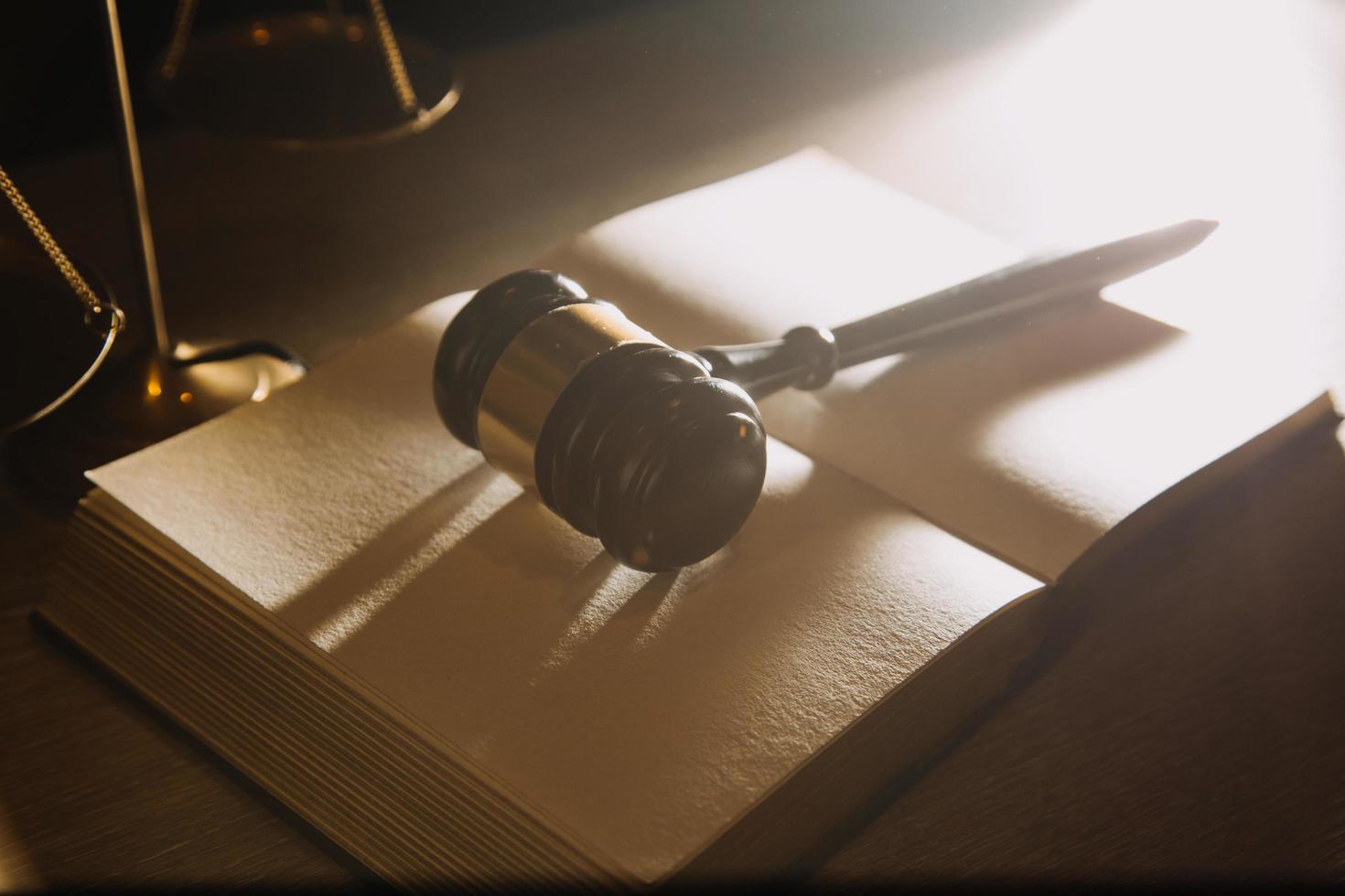 Business and lawyers discussing contract papers with brass scale on desk in office. Law, legal services, advice, justice and law concept picture with film grain effect photo