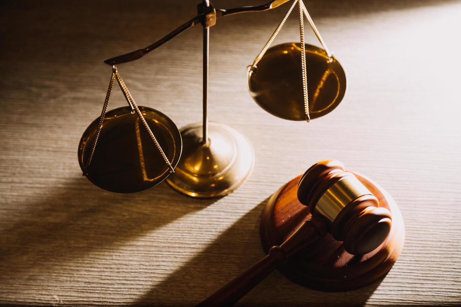 Business and lawyers discussing contract papers with brass scale on desk in office. Law, legal services, advice, justice and law concept picture with film grain effect photo