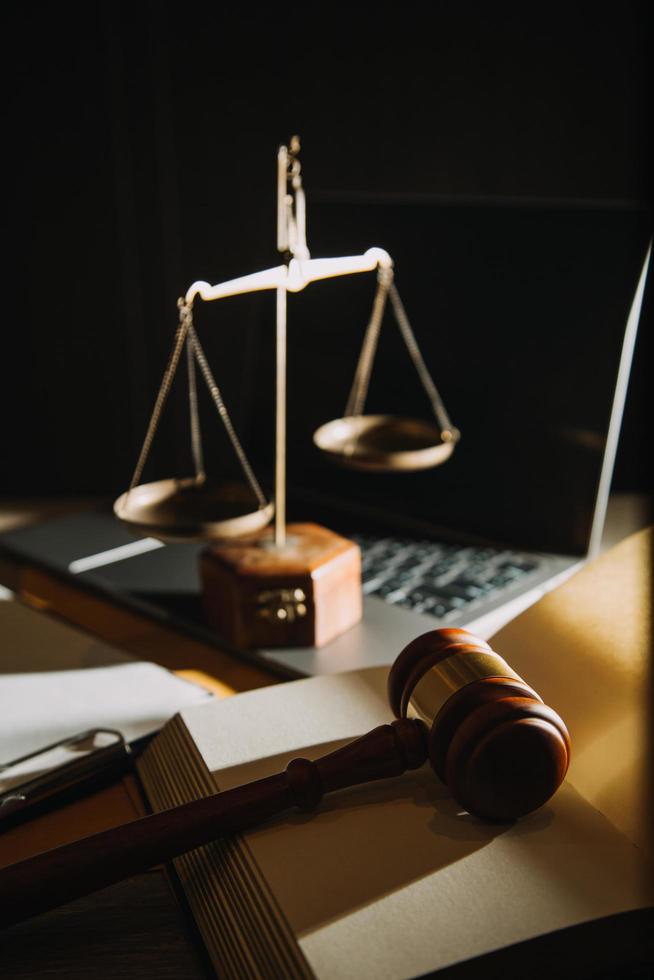 law books and scales of justice on desk in library of law firm. jurisprudence legal education concept. photo