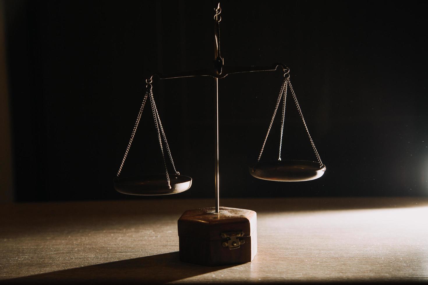 law books and scales of justice on desk in library of law firm. jurisprudence legal education concept. photo