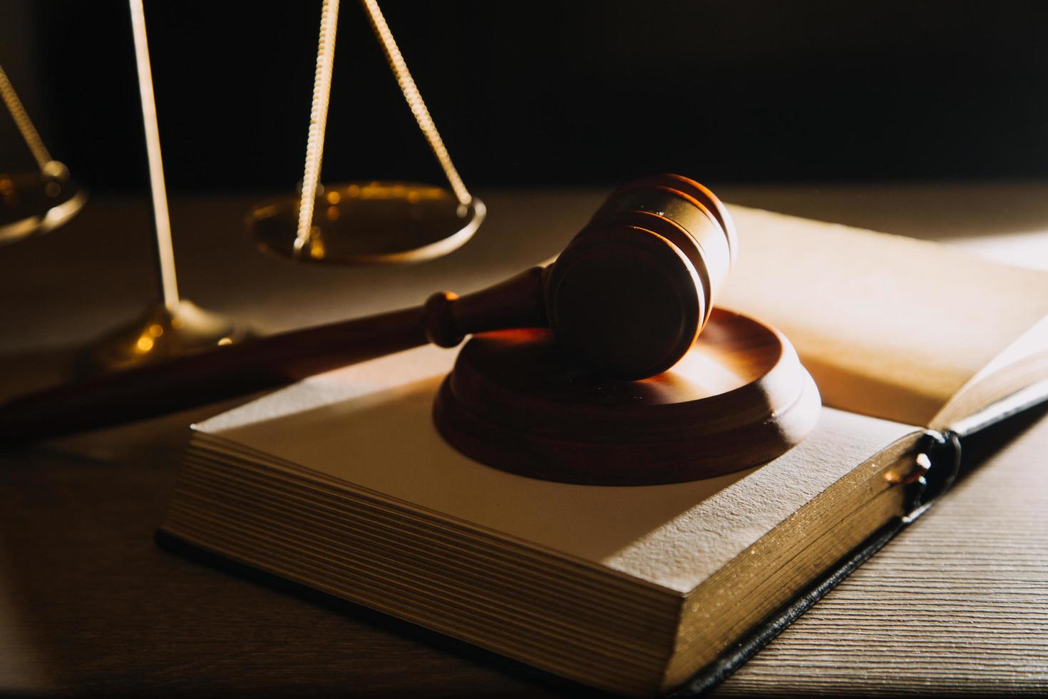 Business and lawyers discussing contract papers with brass scale on desk in office. Law, legal services, advice, justice and law concept picture with film grain effect photo