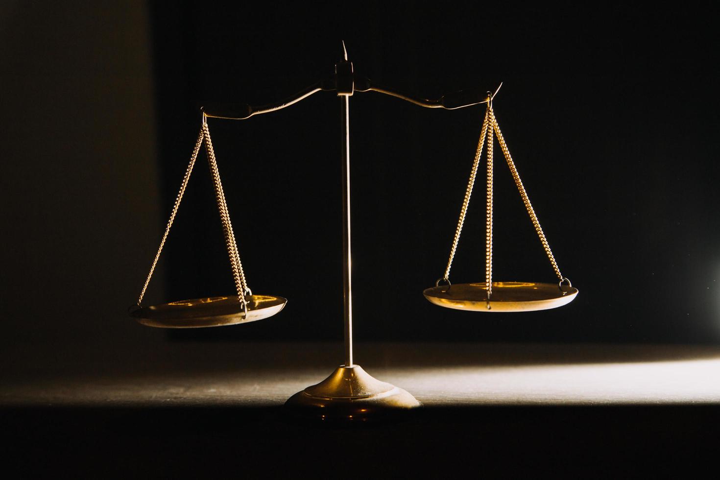 law books and scales of justice on desk in library of law firm. jurisprudence legal education concept. photo