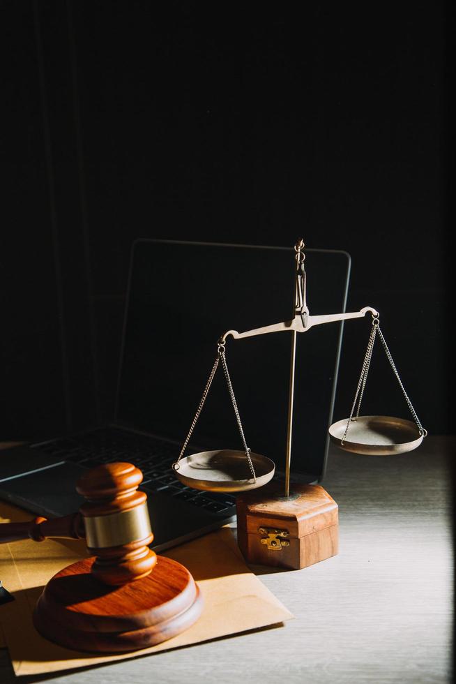 Business and lawyers discussing contract papers with brass scale on desk in office. Law, legal services, advice, justice and law concept picture with film grain effect photo