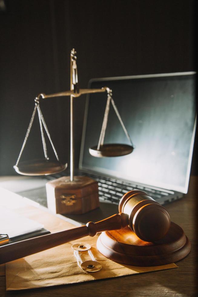 Business and lawyers discussing contract papers with brass scale on desk in office. Law, legal services, advice, justice and law concept picture with film grain effect photo