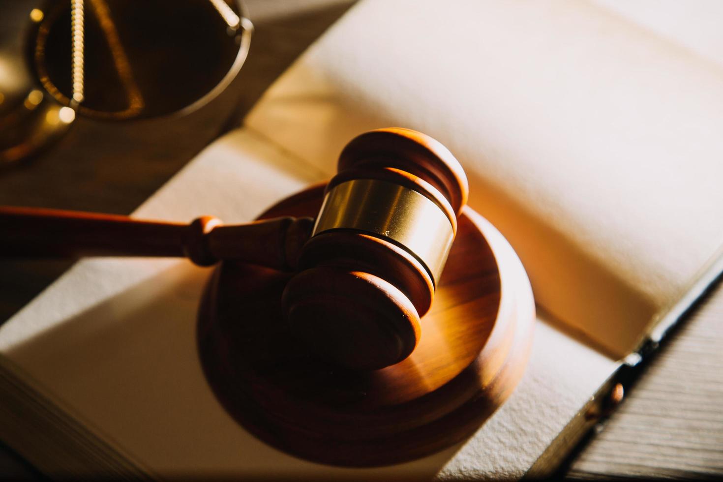 Business and lawyers discussing contract papers with brass scale on desk in office. Law, legal services, advice, justice and law concept picture with film grain effect photo