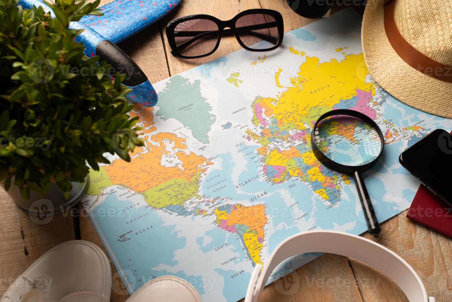 Flat lay traveler accessories on map, camera, glasses, digital devices photo