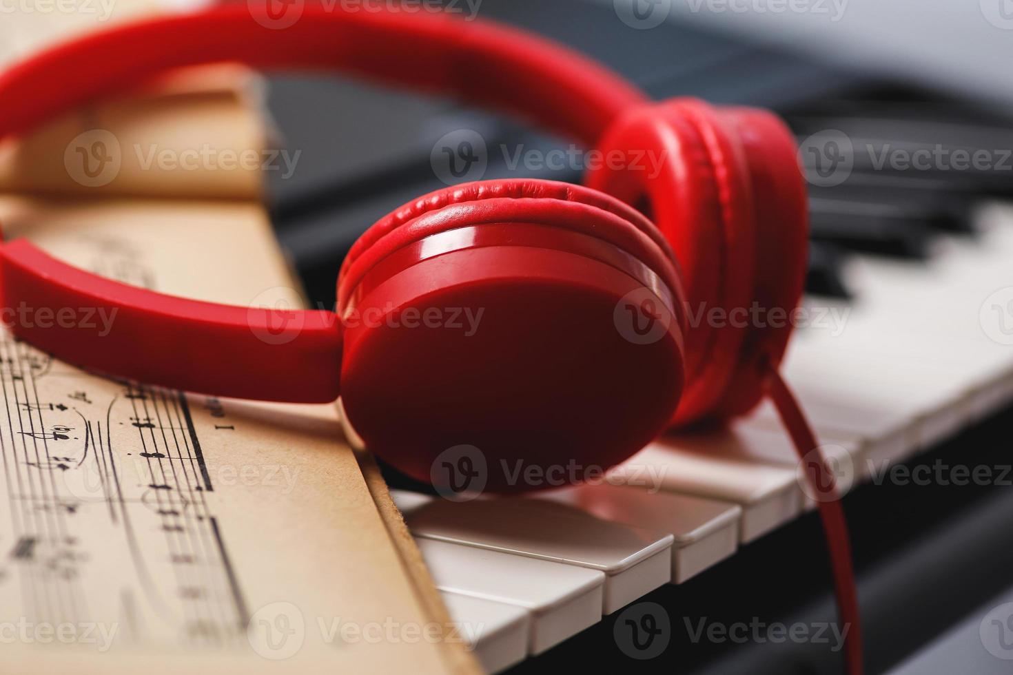 Sheet music and red headphones on the piano keys photo
